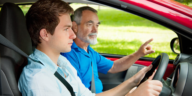 man teaching boy to drive